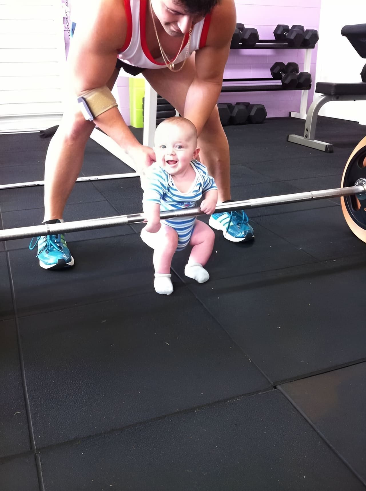 A Baby Is Sitting On A Barbell In A Gym — Maxenergy Fitness In Smithfield, QLD