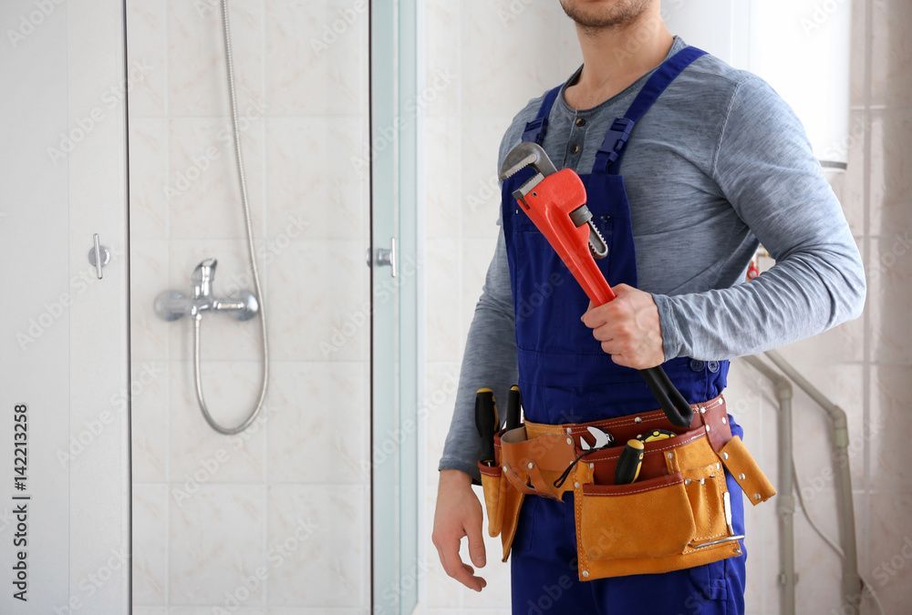 Plumber holding a pipe wrench, showcasing residential plumbing services for home repairs. Plumber holding a pipe wrench, showcasing residential plumbing services for home repairs.
