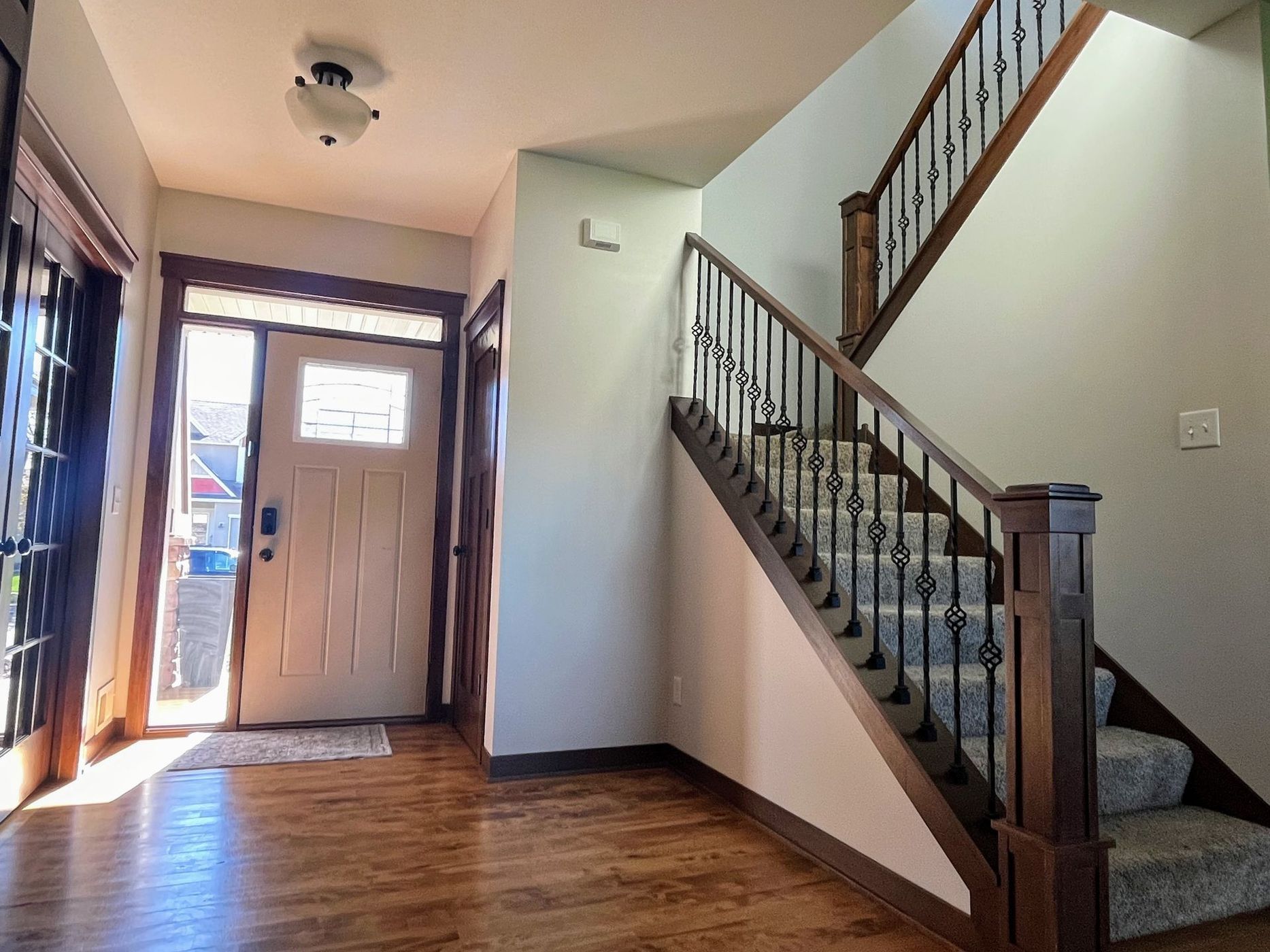 A hallway with stairs leading up to the second floor of a house.