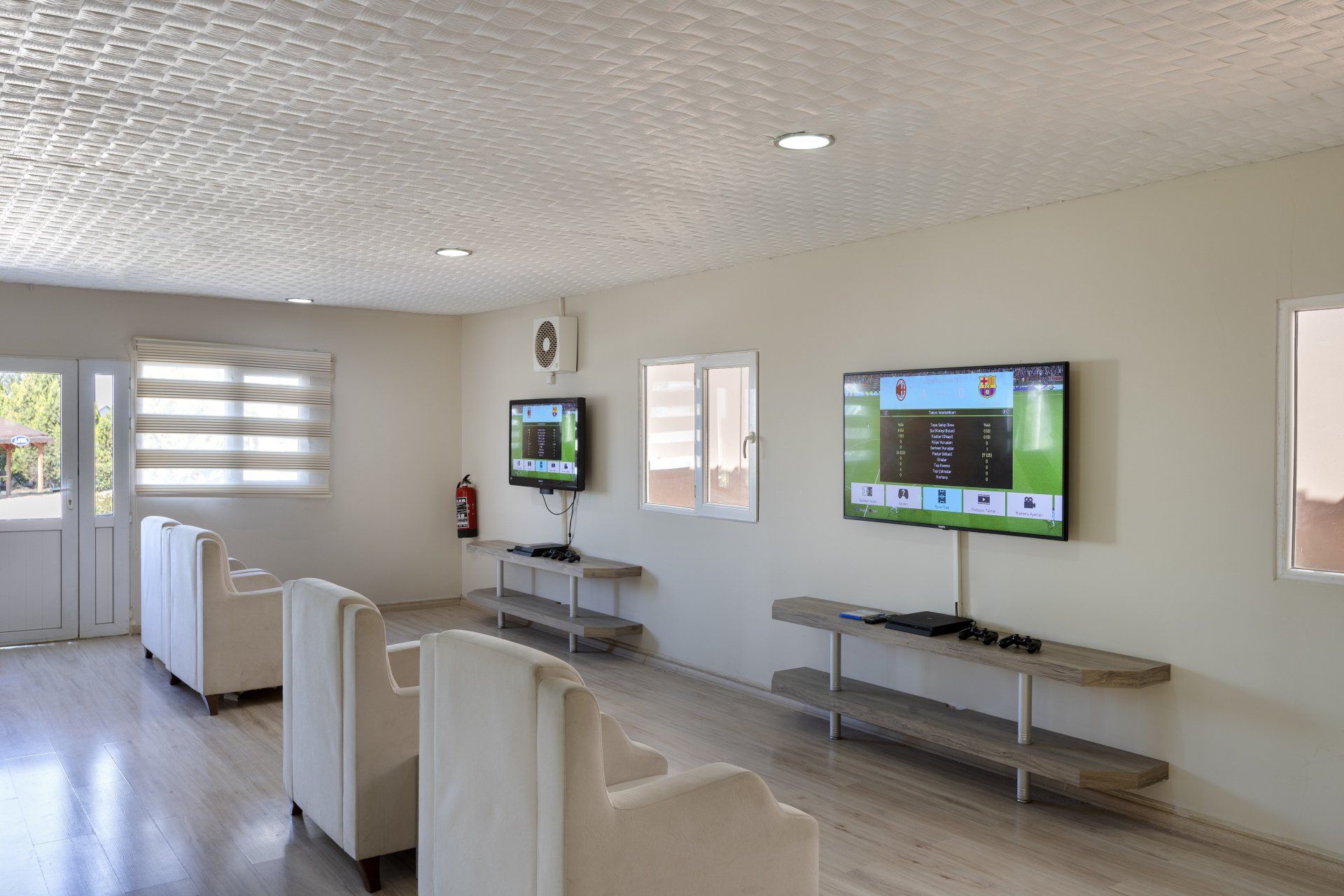 Ein Wohnzimmer mit vielen Möbeln und zwei Fernsehern an der Wand.