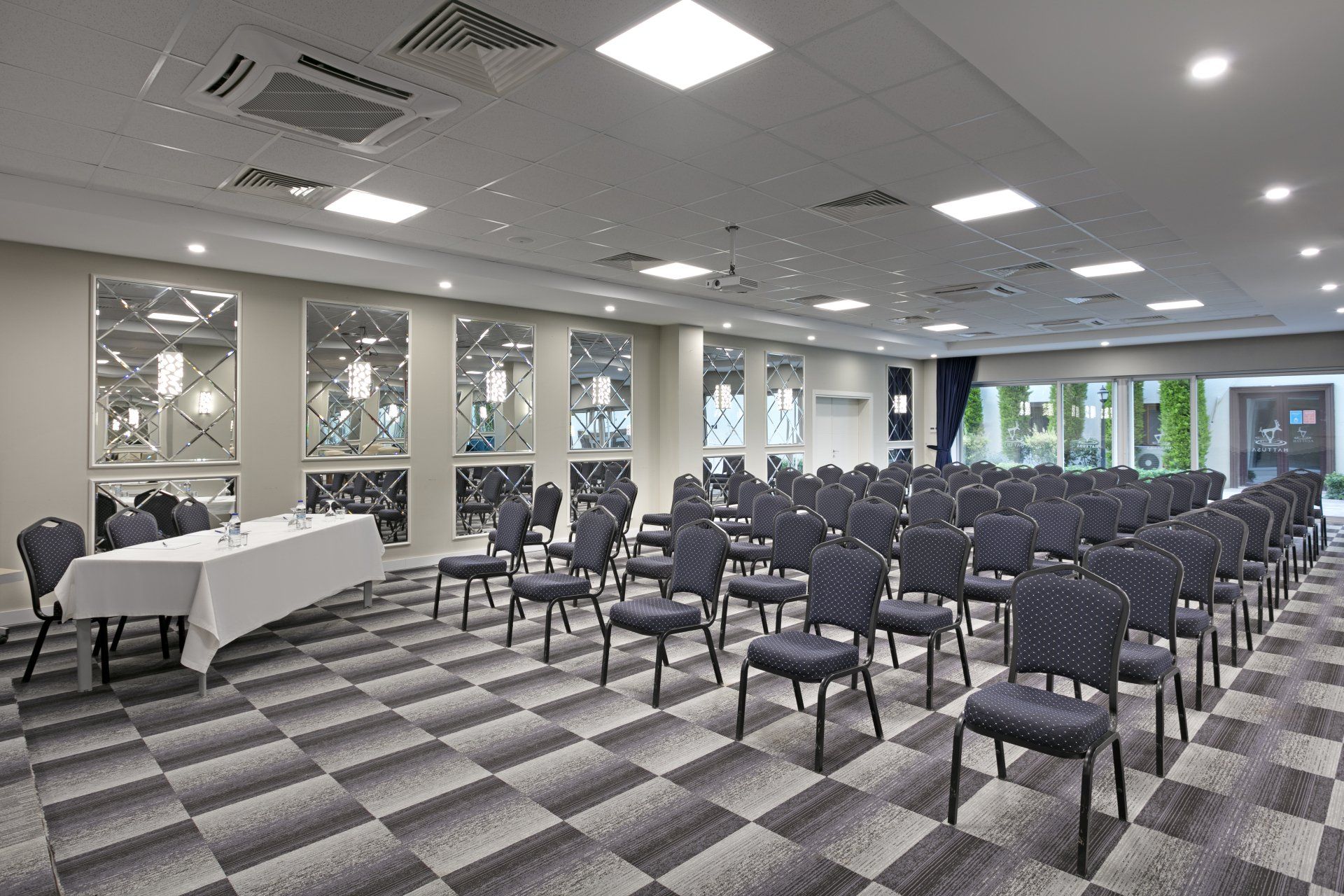 A large conference room with rows of chairs and a table.