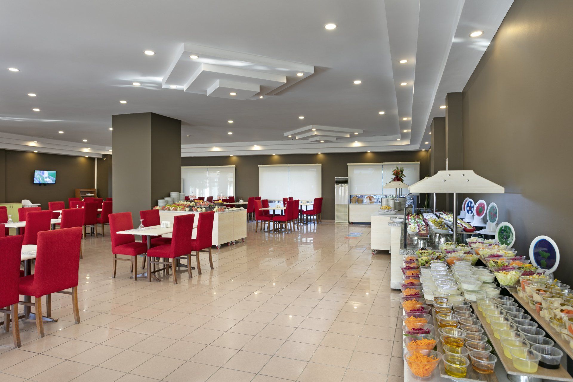 Ein großes Esszimmer mit Tischen und Stühlen und einem Buffet.