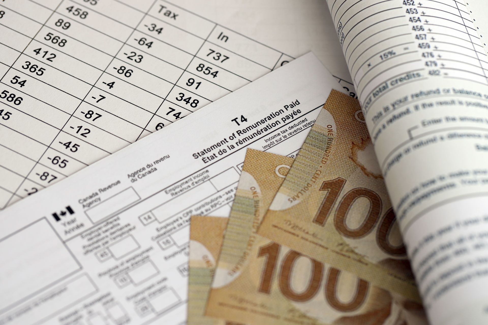 Formulaires fiscaux, devises canadiennes et documents, probablement liés à des calculs financiers.