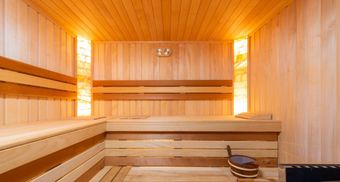 a wooden sauna with a bucket on the bench and sauna pillow
