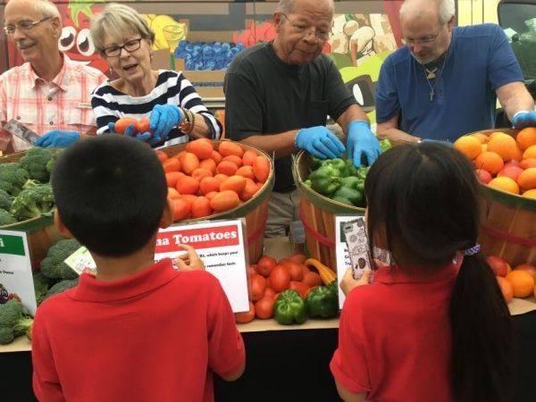 Four volunteers distributing fresh produce at NourishNC