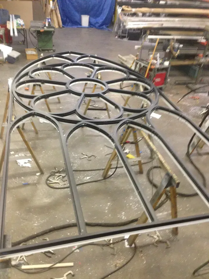 A large metal structure is being built in a factory.
