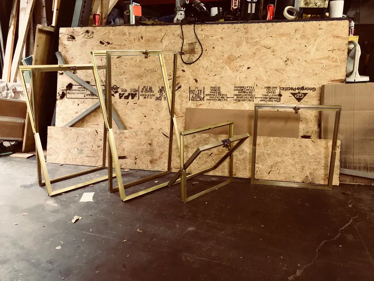 A group of metal frames are sitting in front of a wooden wall.