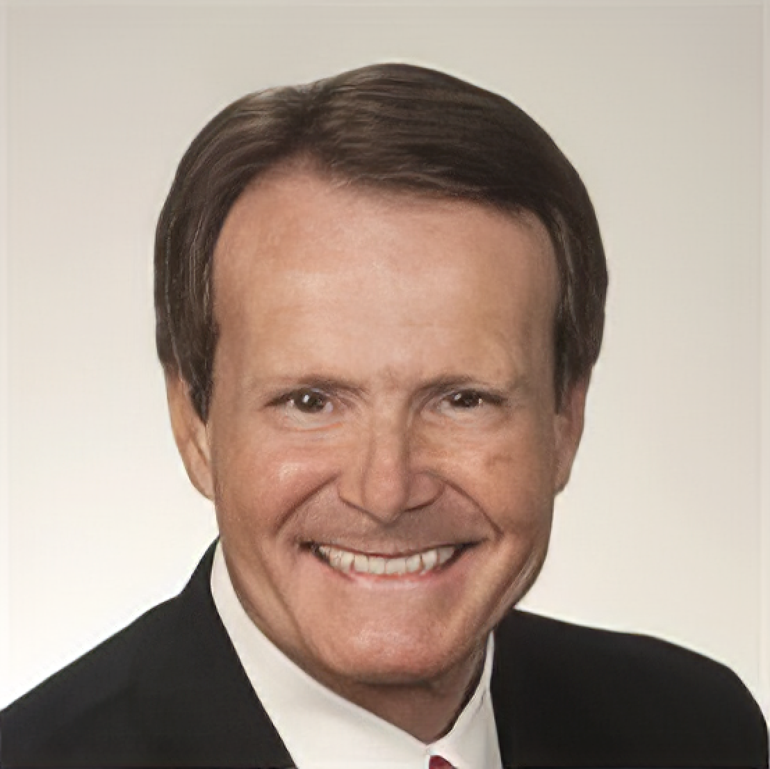 A man in a suit and tie smiles for the camera