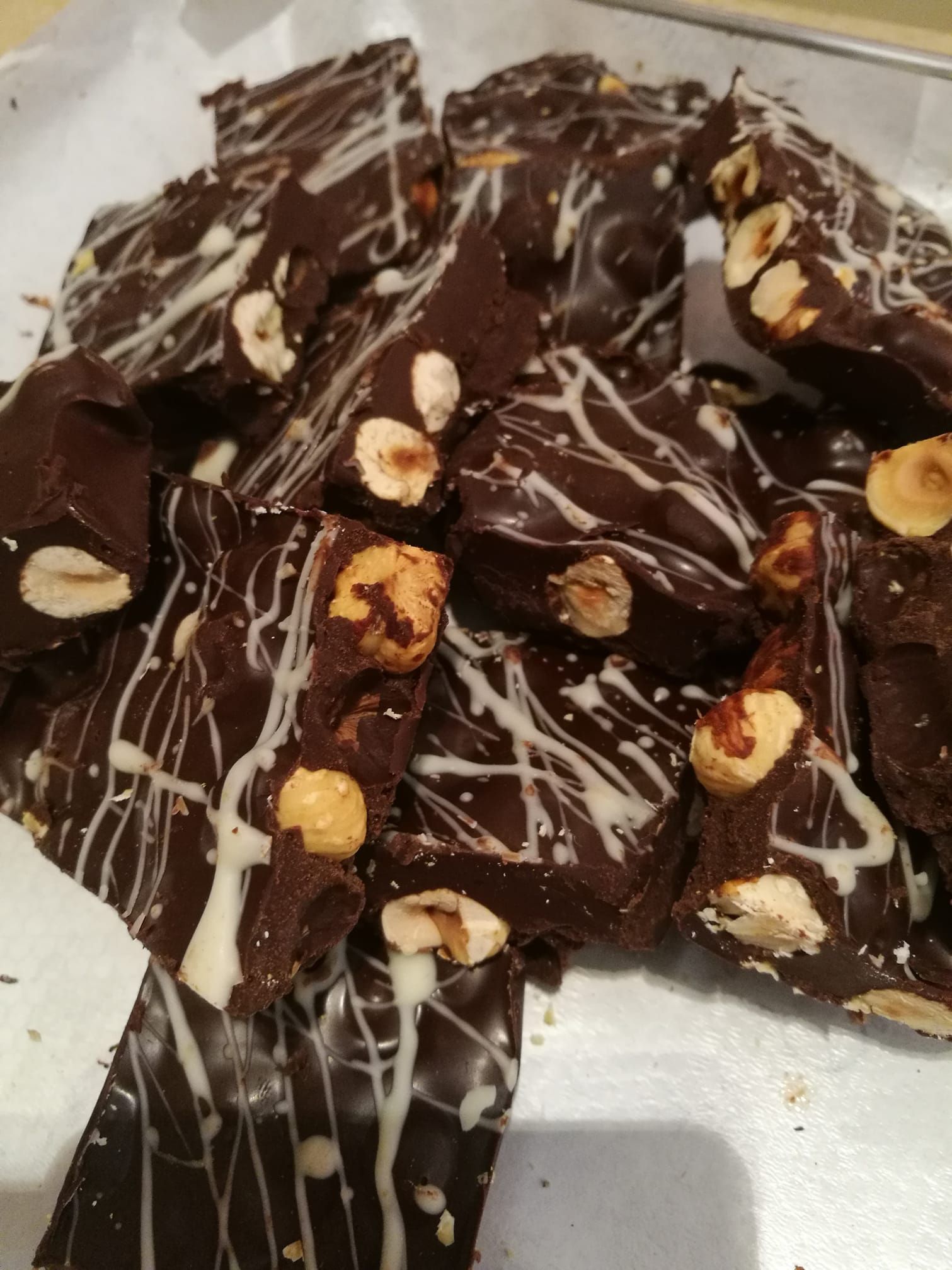 Tavoletta di cioccolato ricoperta di glassa bianca e noci su un vassoio