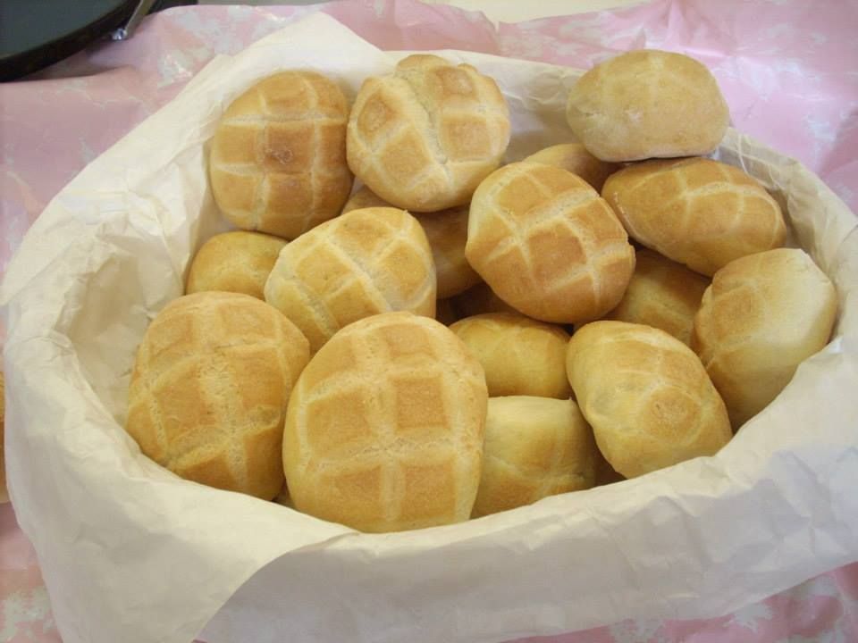 Un cestino di panini rotondi, dorati e con la superficie a griglia.