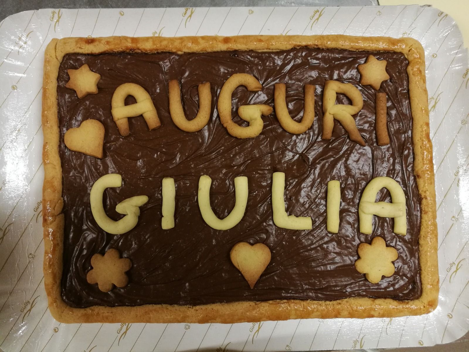 Torta al cioccolato con glassa gialla con la scritta