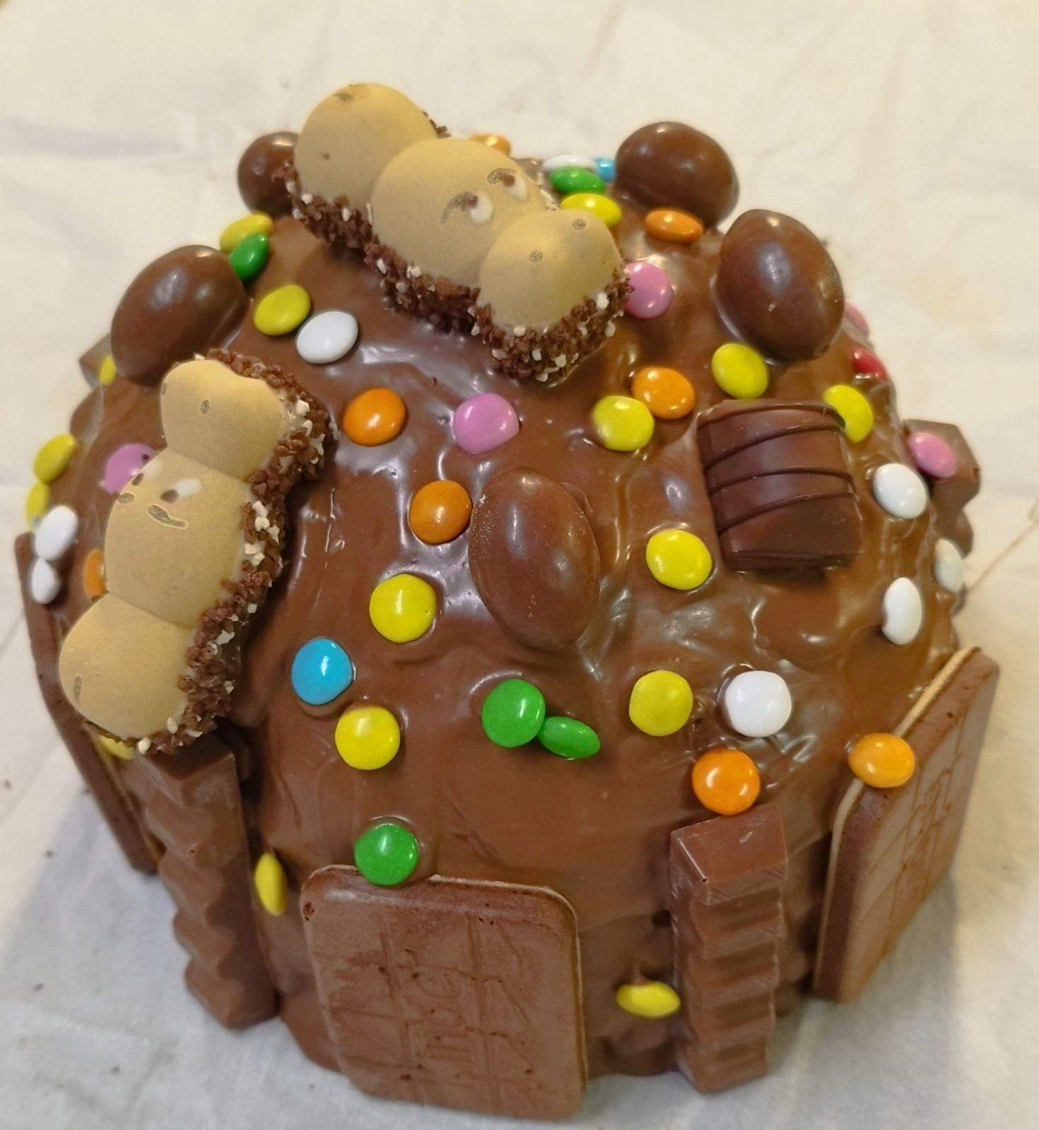 Torta al cioccolato con pezzetti di caramelle colorate e biscotti wafer.