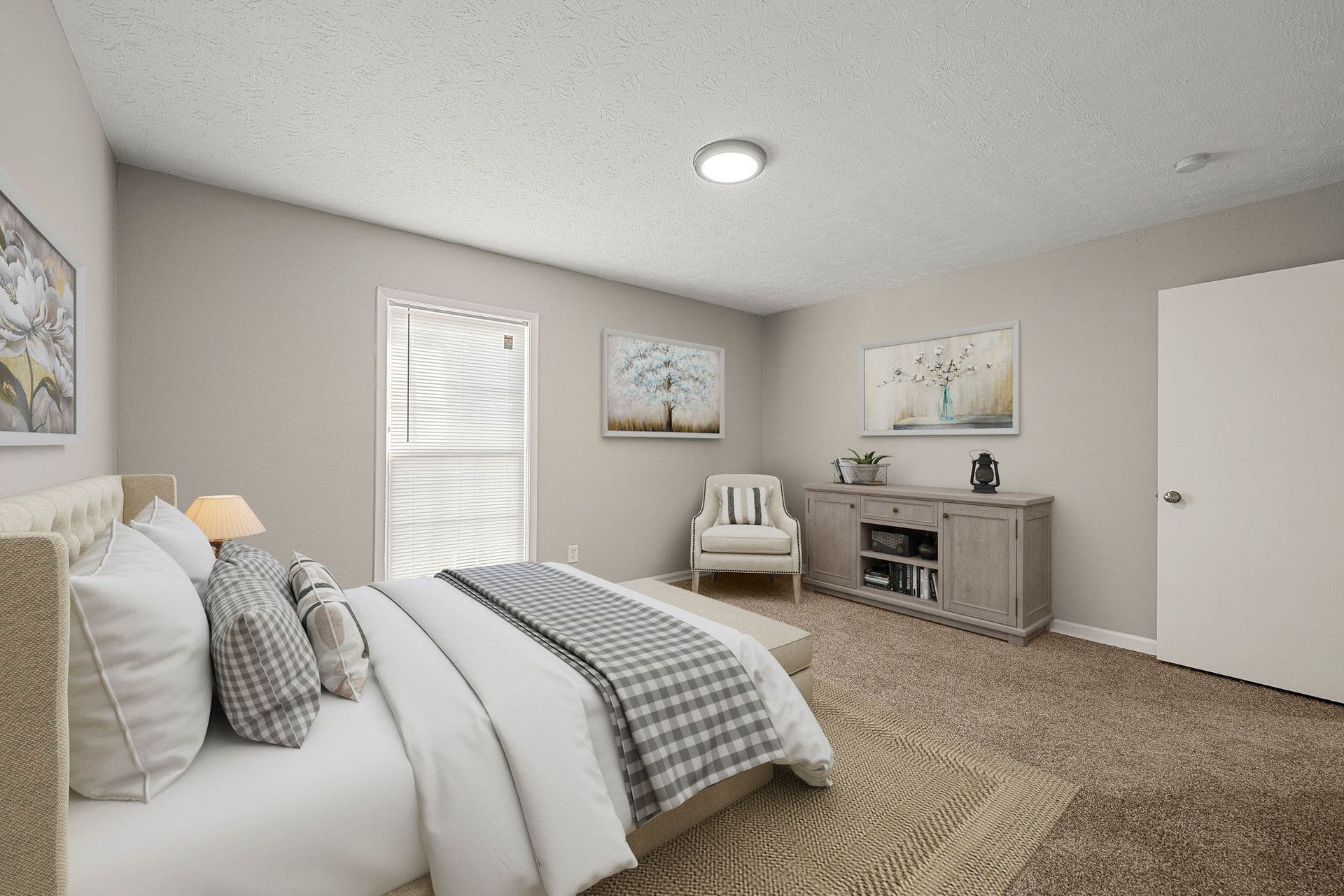 Cozy beige bedroom with a bed, chair, dresser, and two wall paintings.