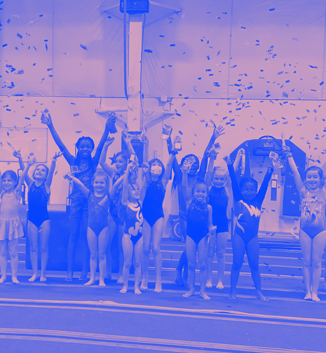 A group of young girls are posing for a picture with their arms in the air