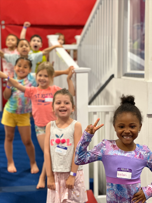 A group of young girls are posing for a picture in a gym.