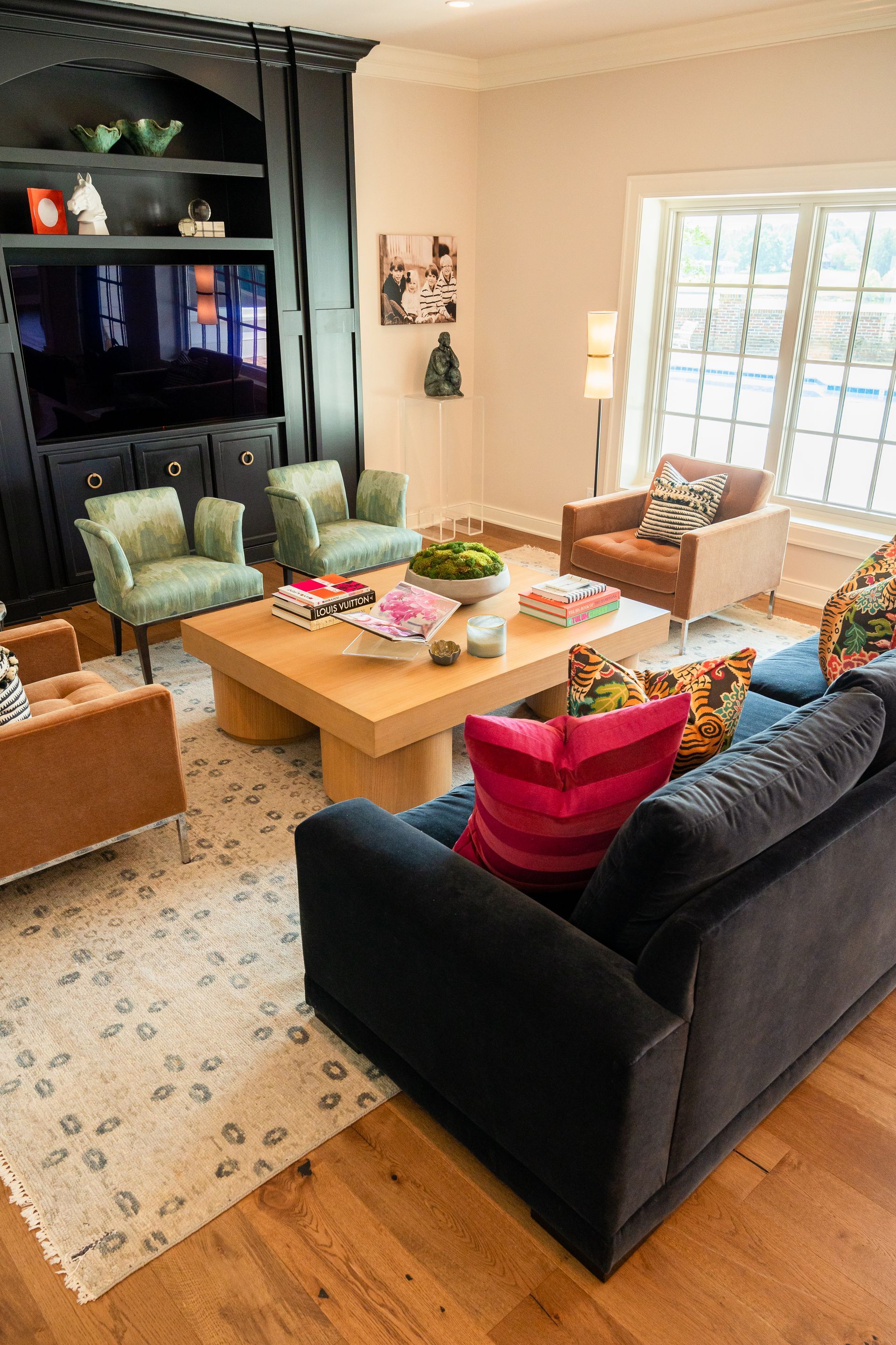 A living room with a couch , chairs , coffee table and television.