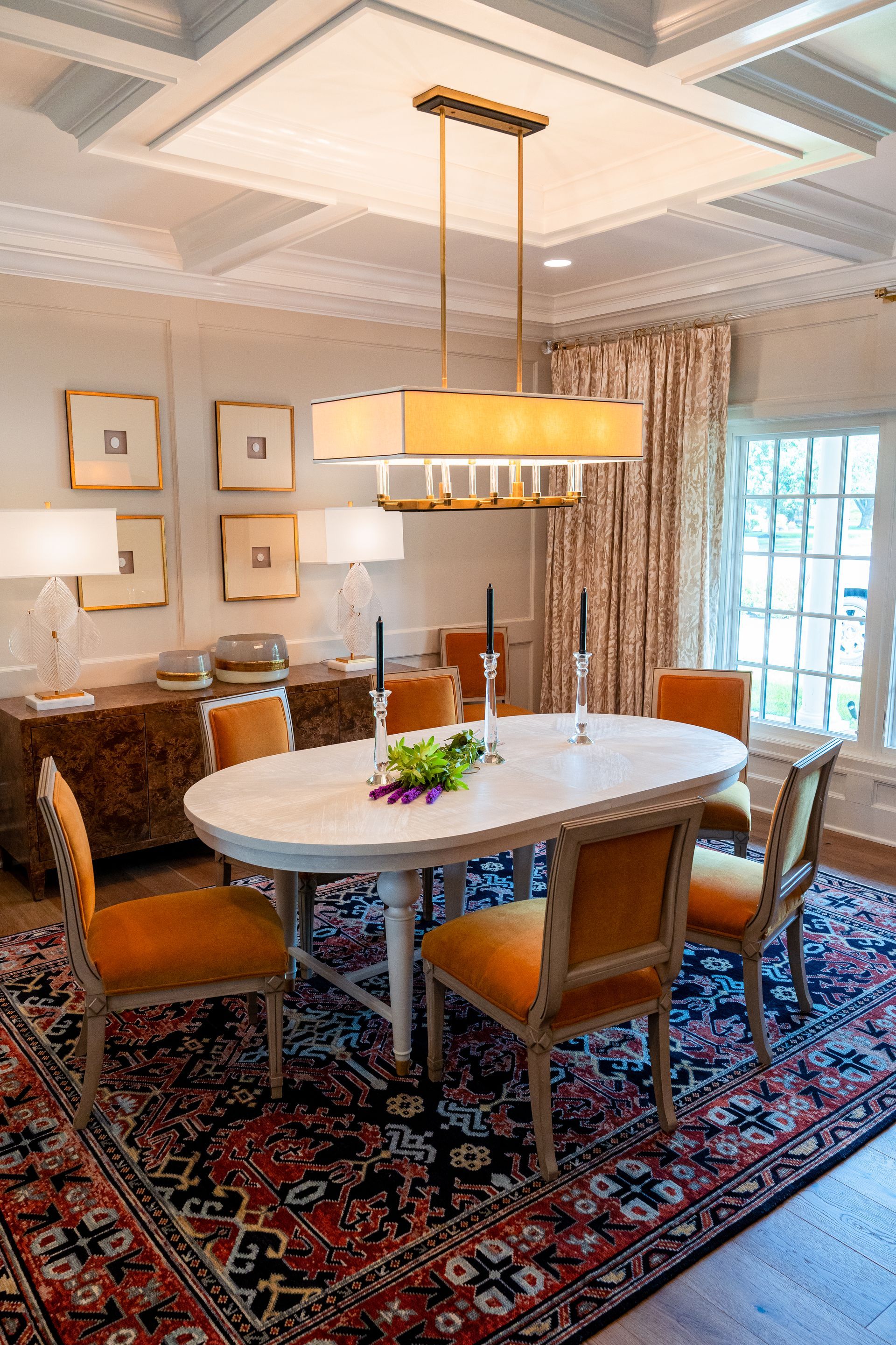 A dining room with a table and chairs and a rug.