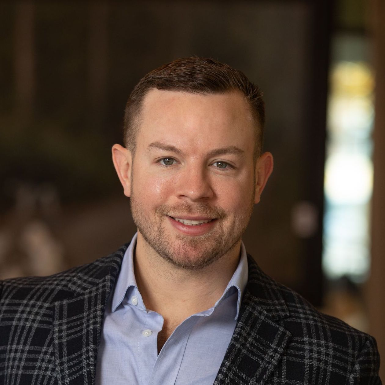 A man in a suit and blue shirt is smiling for the camera.