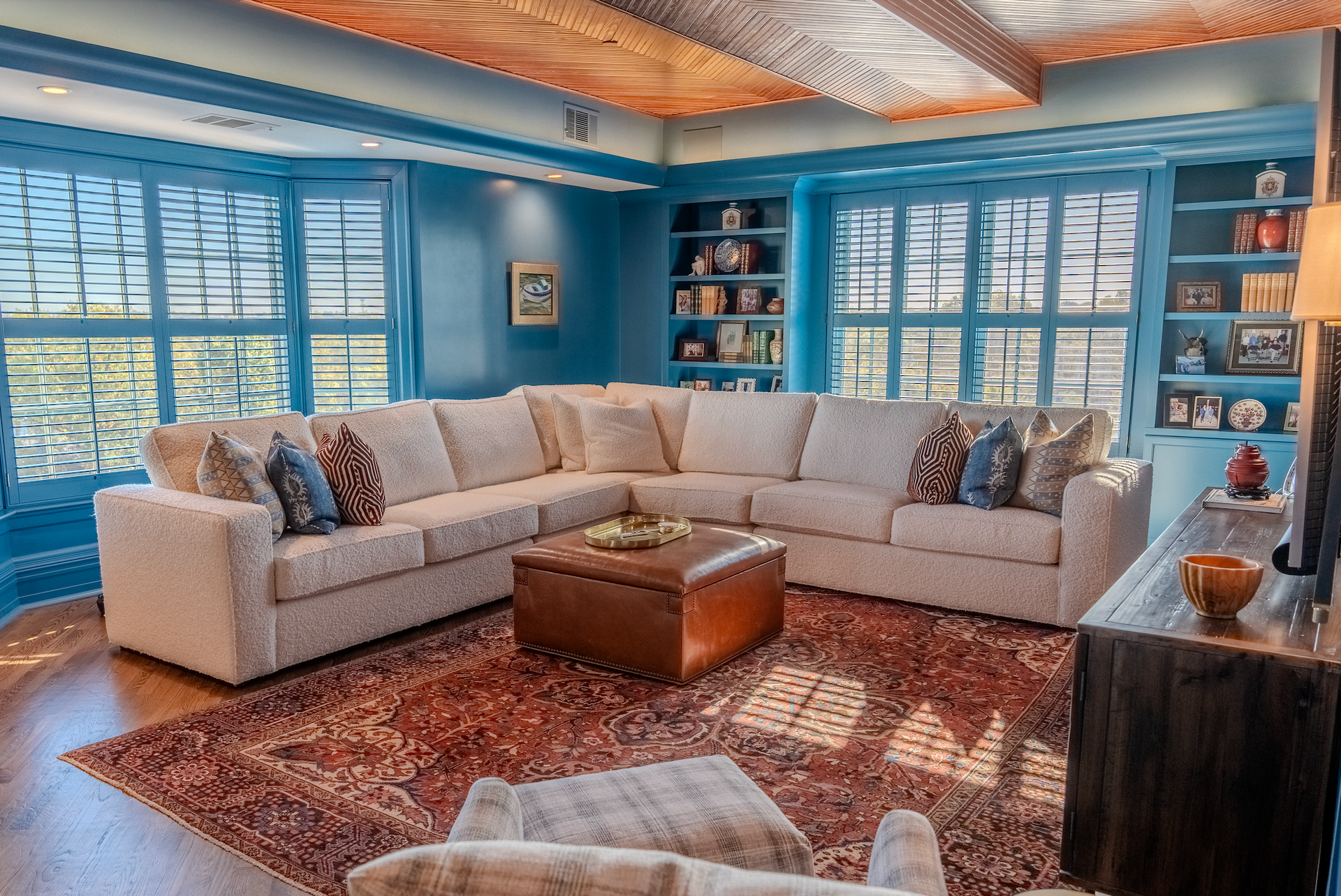A living room with a large sectional couch and a rug.