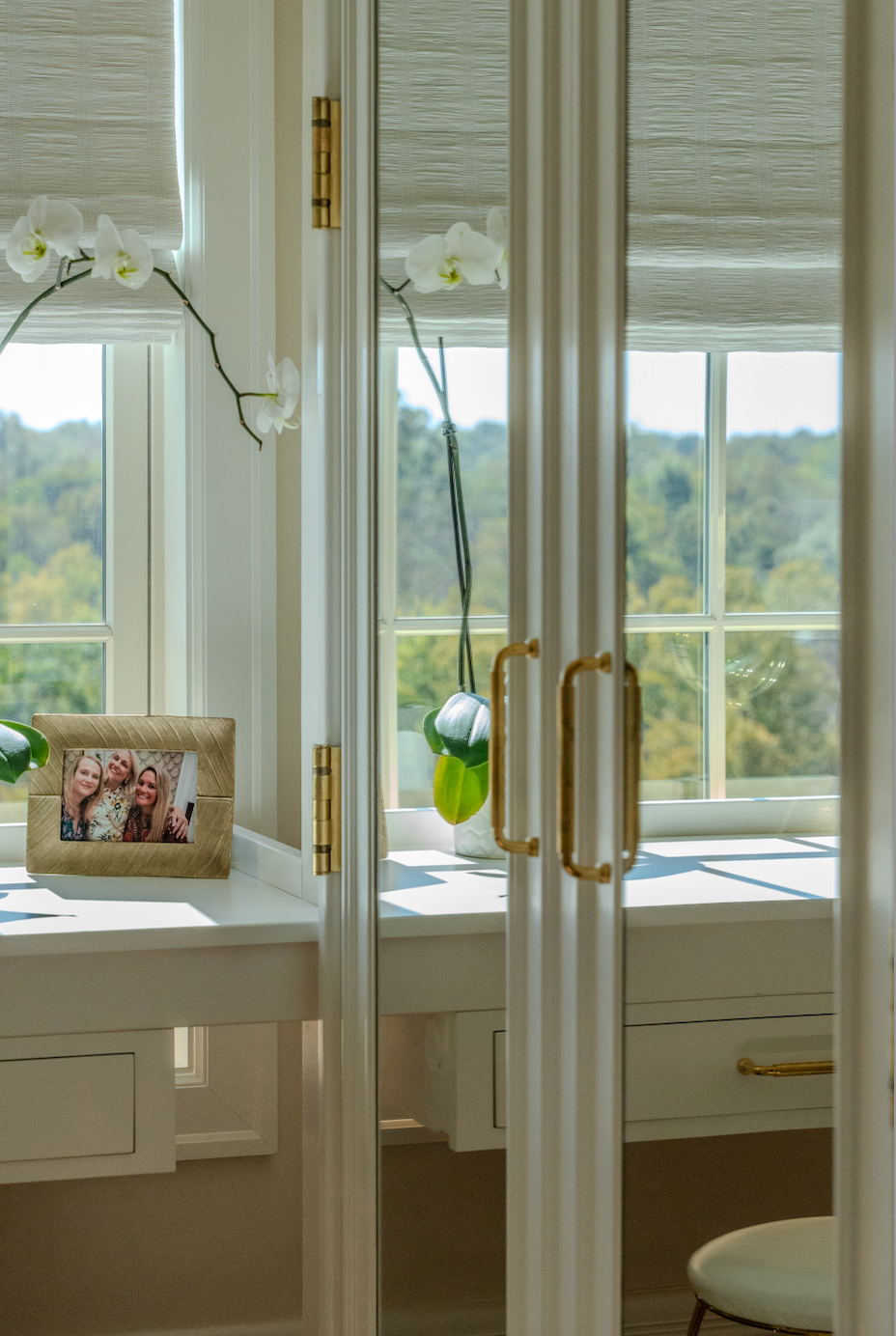 A picture frame is sitting on a table in front of a window.