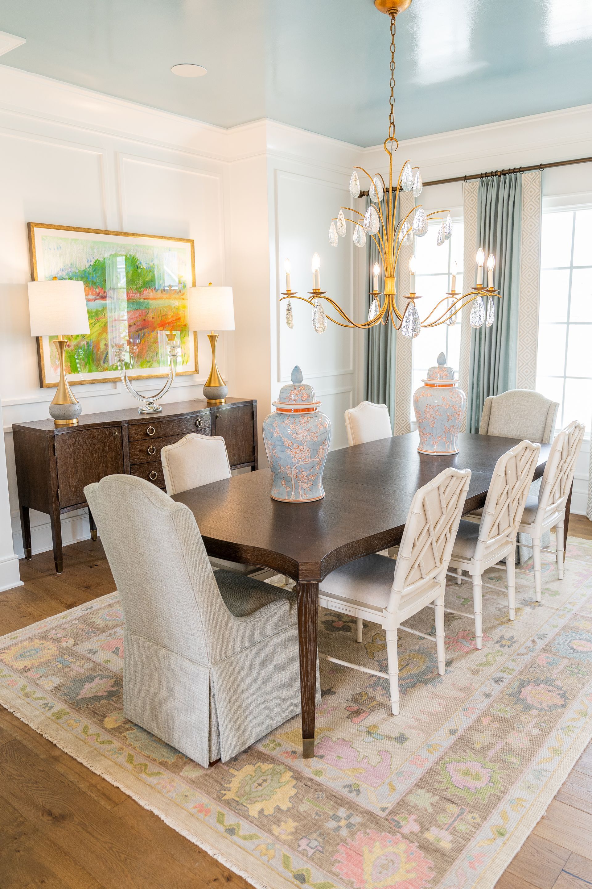 A dining room with a long table and chairs and a chandelier.