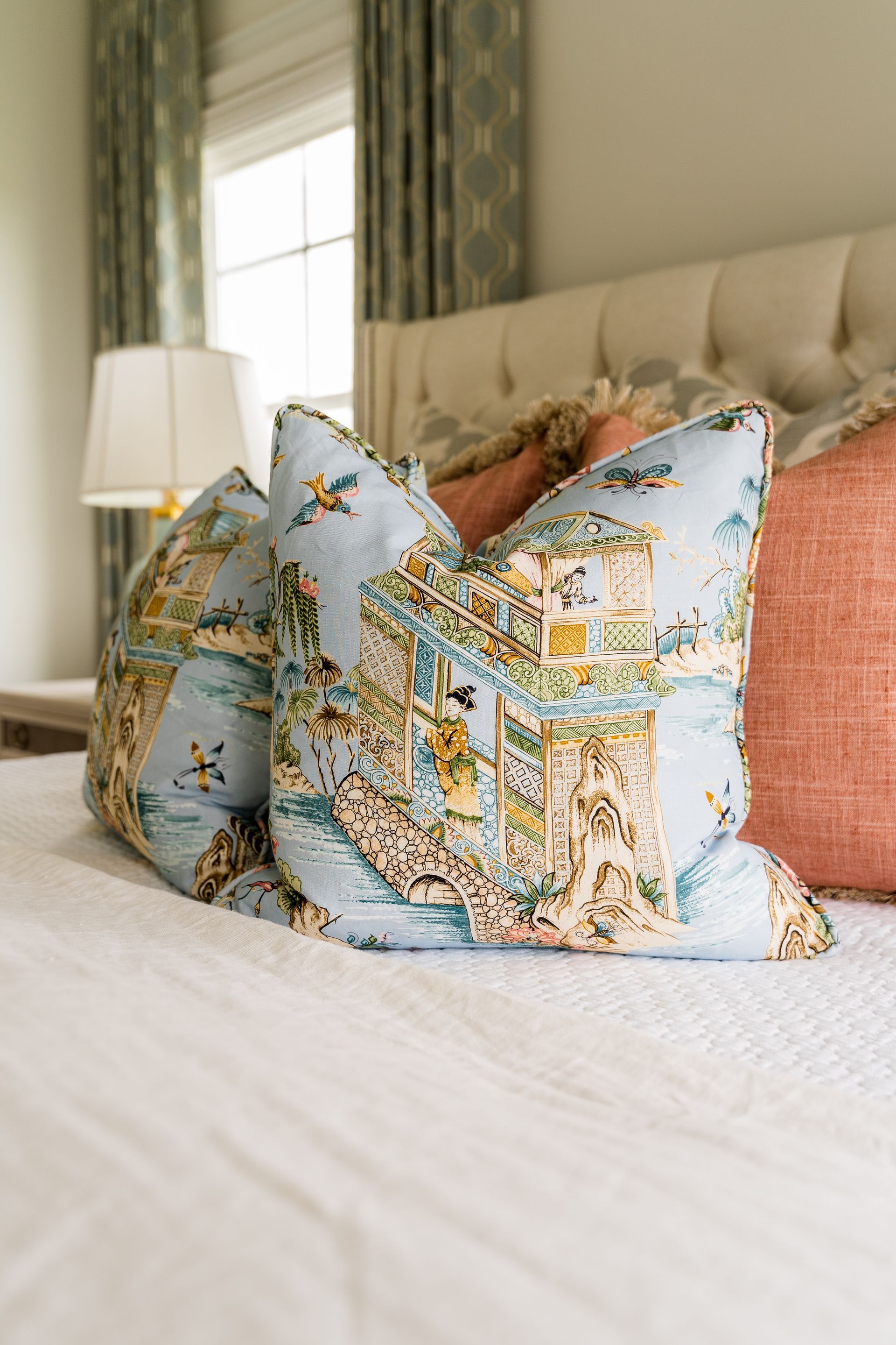 A bed with a lot of pillows on it in a bedroom.