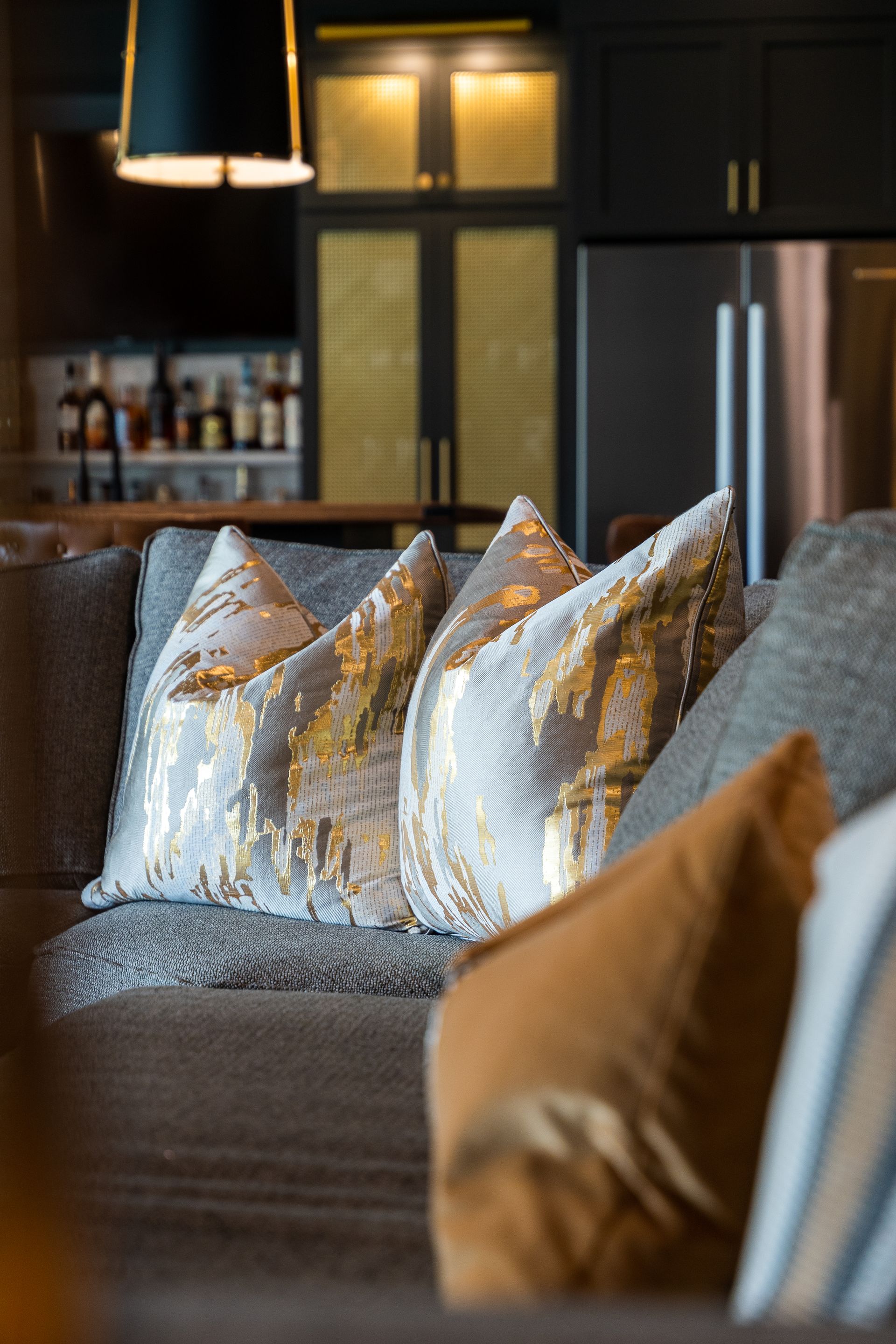 A couch with a lot of pillows on it in a living room.