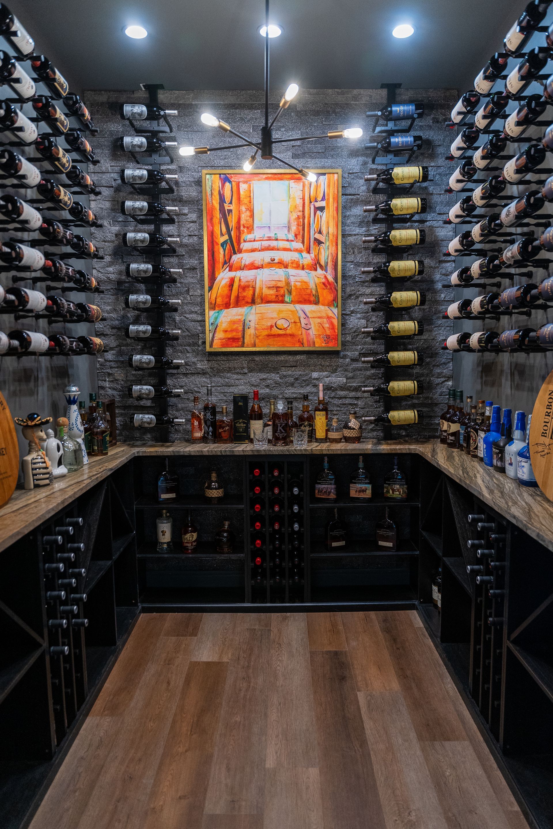 A wine cellar filled with lots of wine bottles and a painting on the wall.