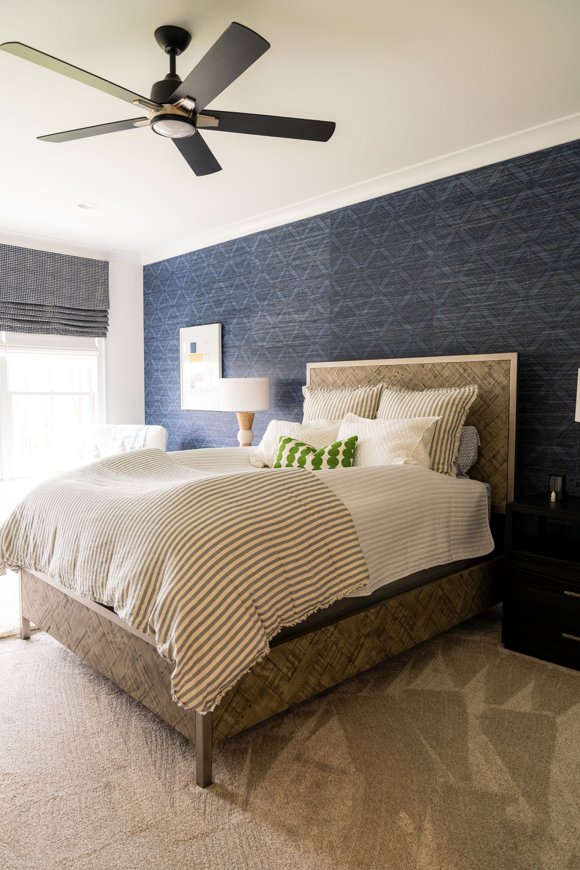 A bedroom with a bed and a ceiling fan.