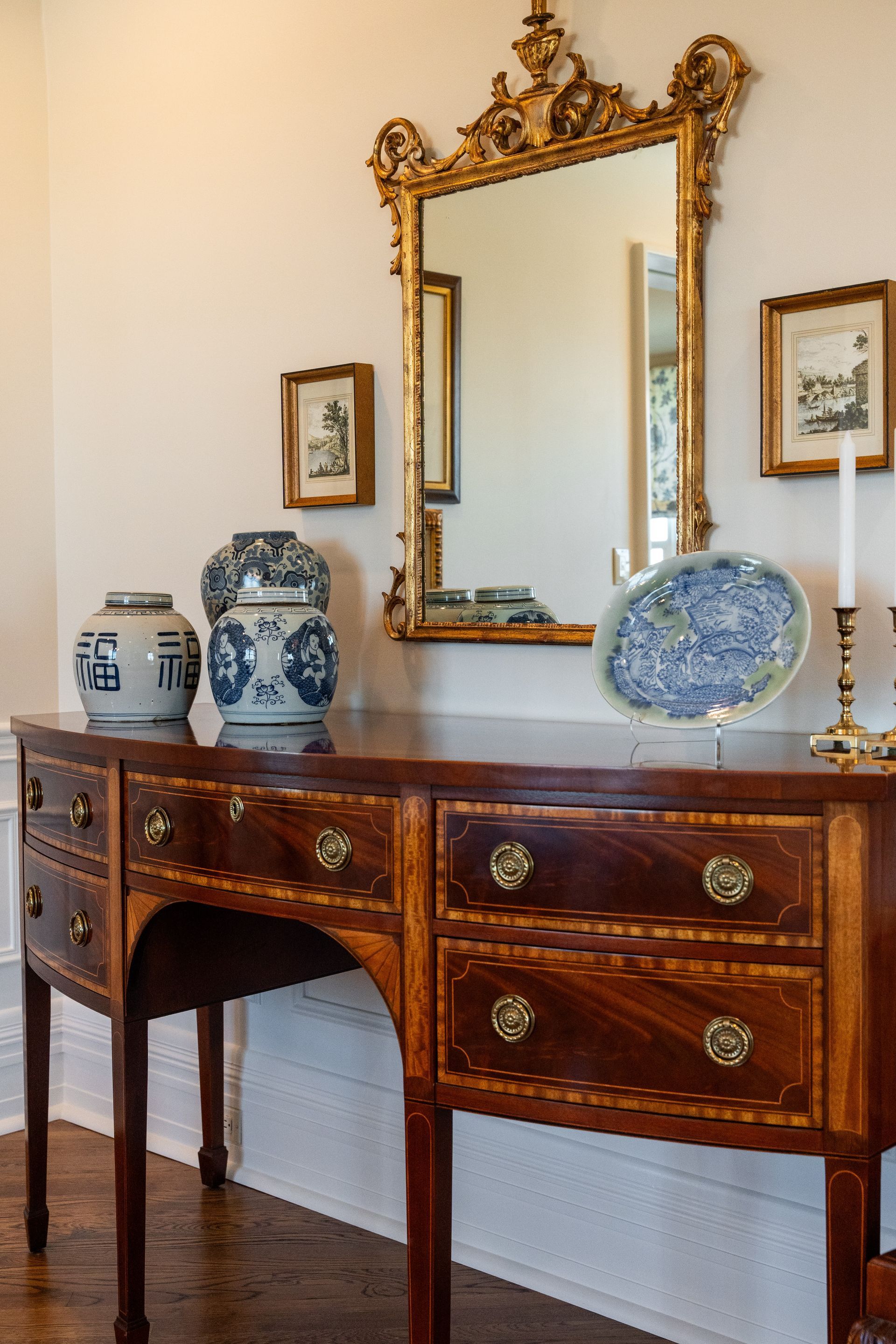 A wooden desk with a mirror and vases on it in a room.