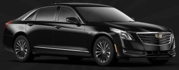 A black cadillac is parked on a black background.