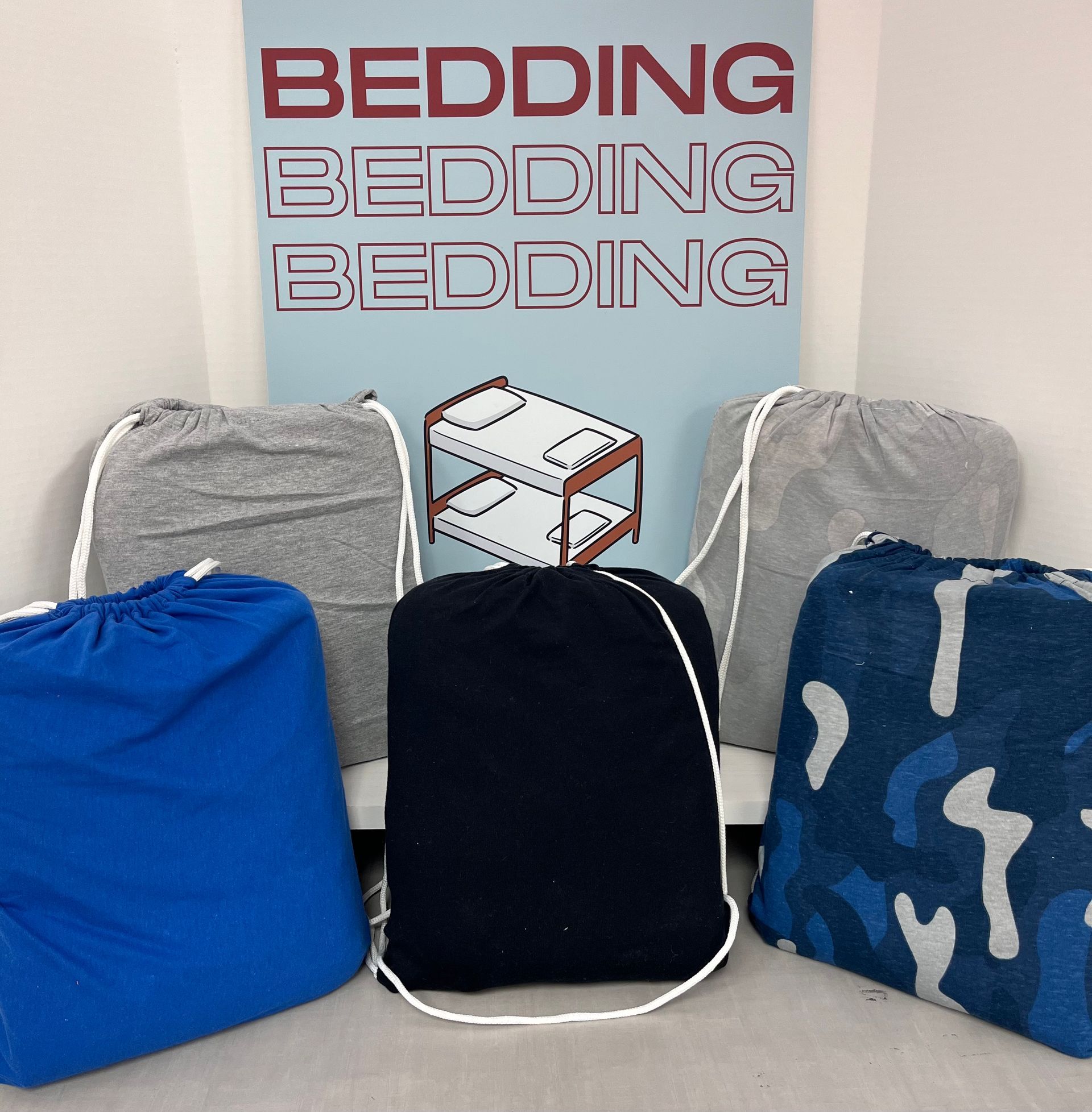 a bunch of drawstring bags are sitting in front of a sign that says bedding bedding bedding