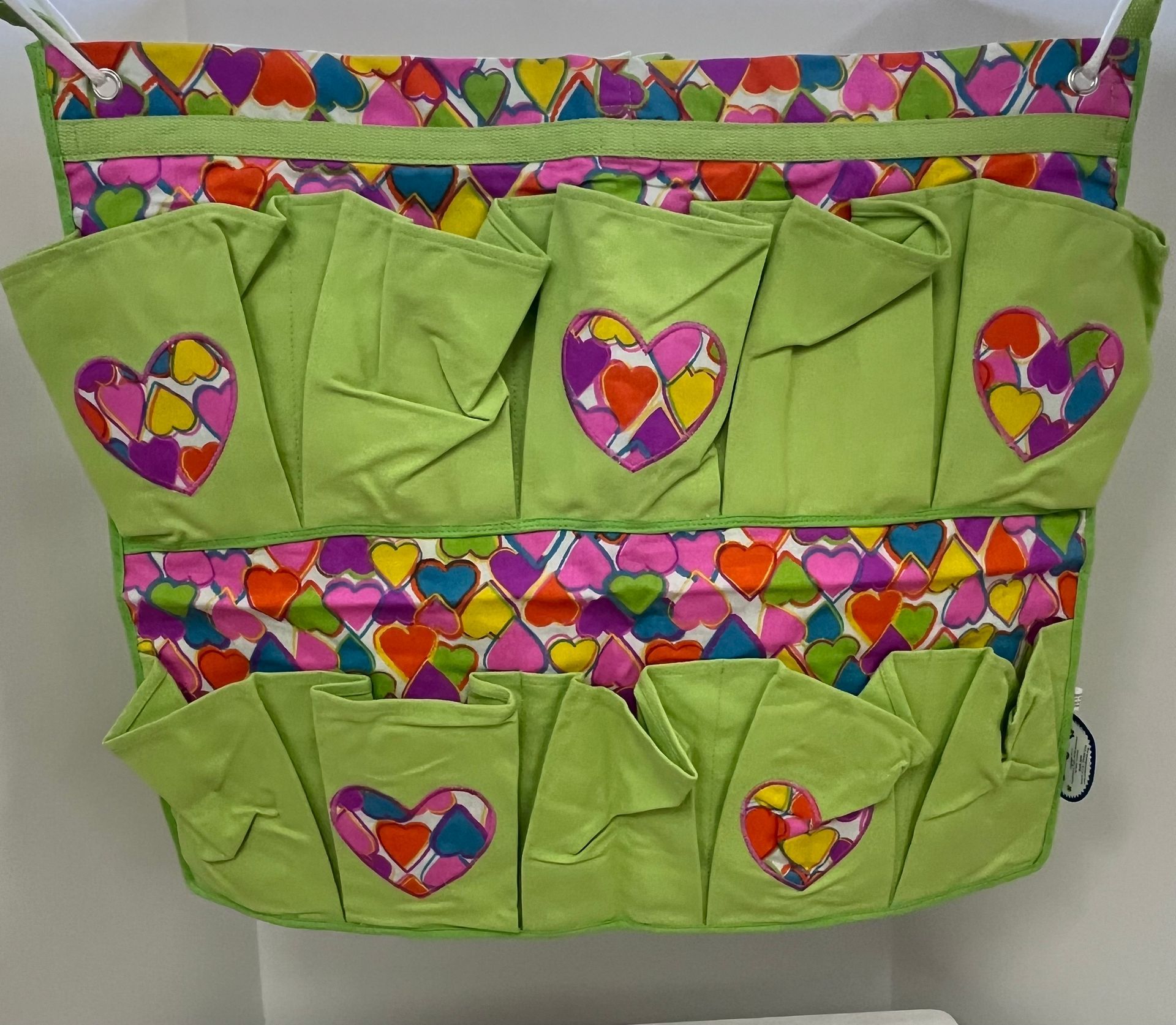a green bag with colorful hearts on it