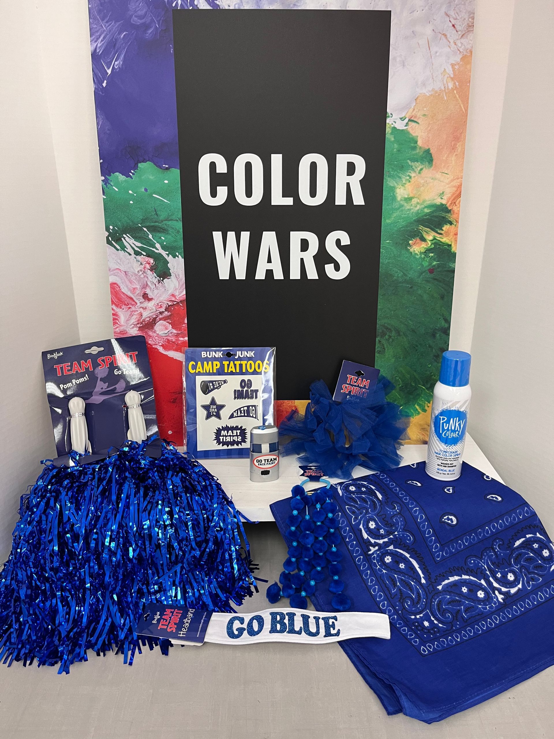 a bunch of blue items are on a table with a sign that says color wars