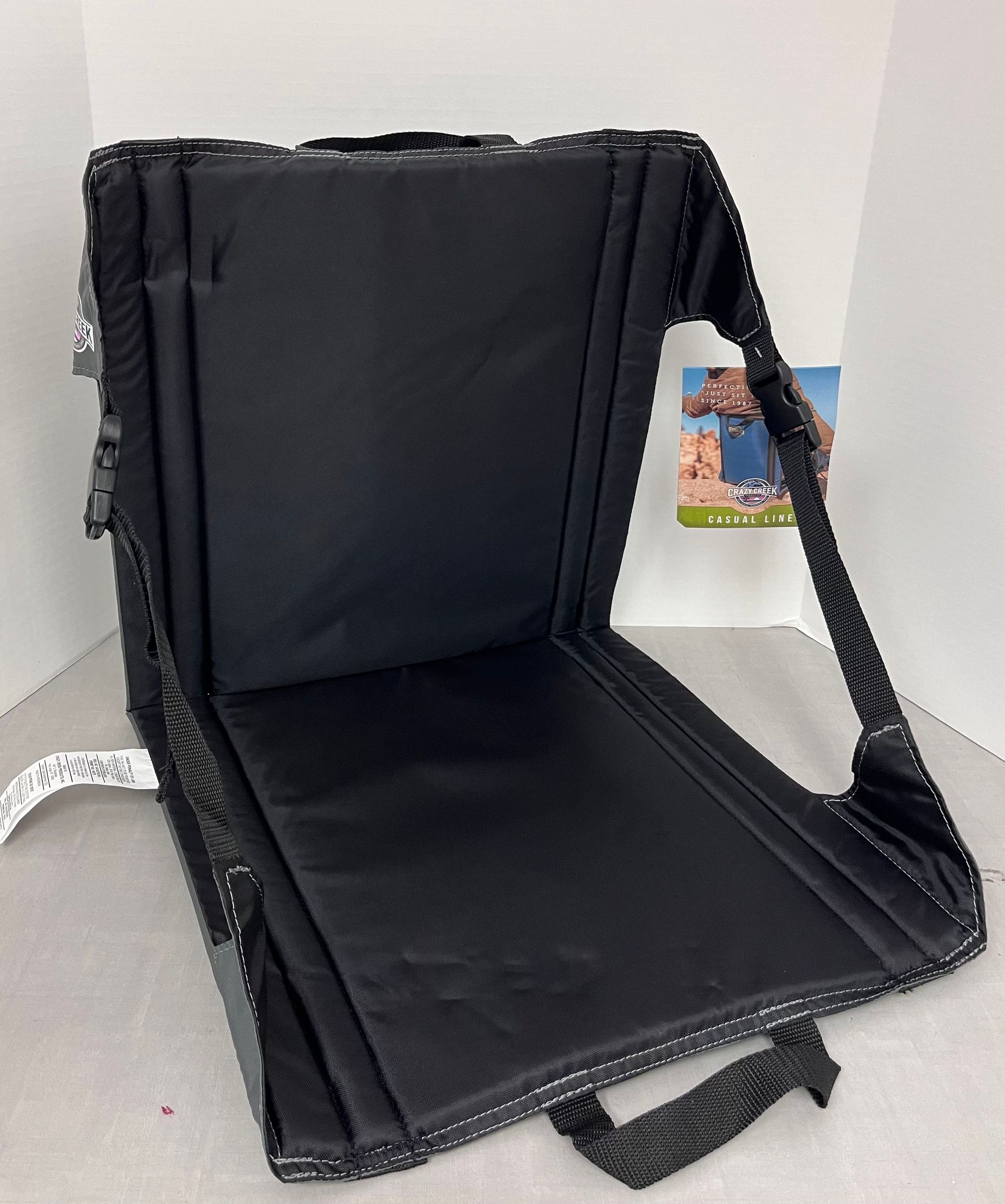 a black folding chair with a handle is sitting on a table .