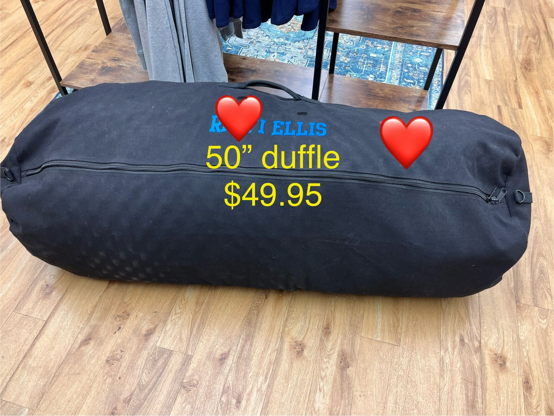 a black duffel bag is sitting on a wooden floor