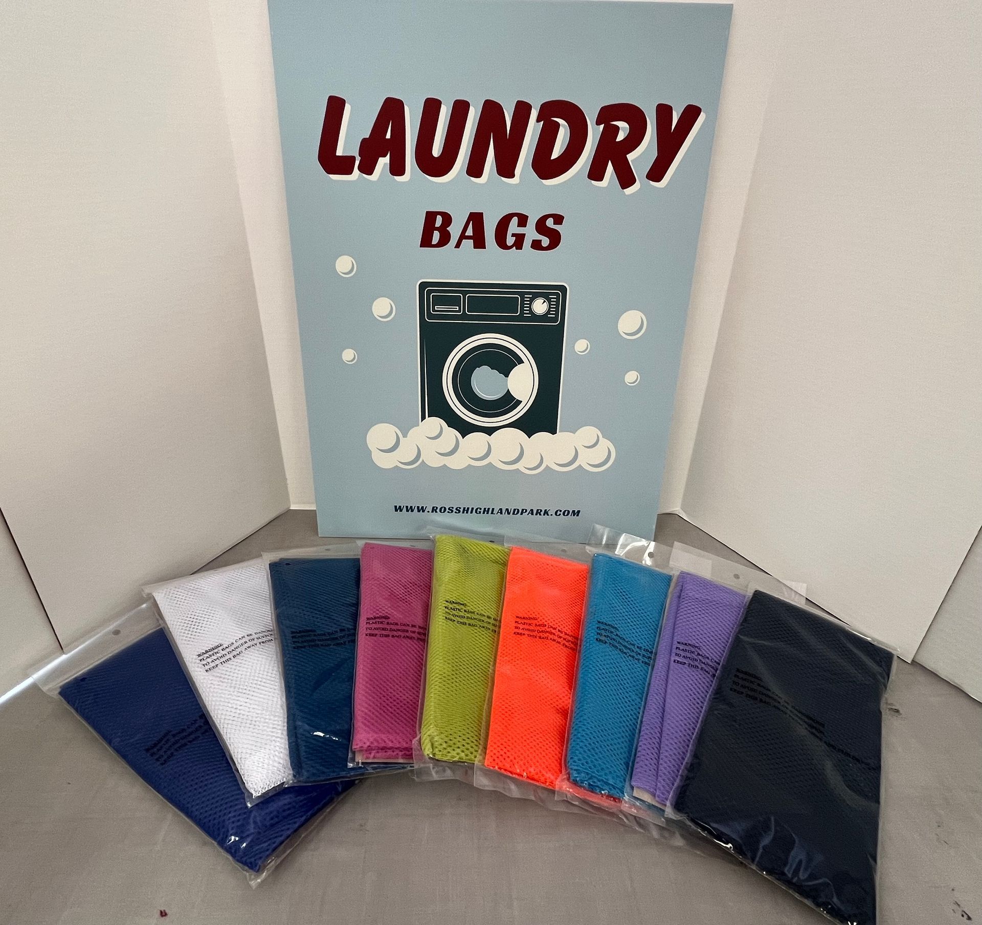 a bunch of laundry bags are lined up in front of a sign that says laundry bags