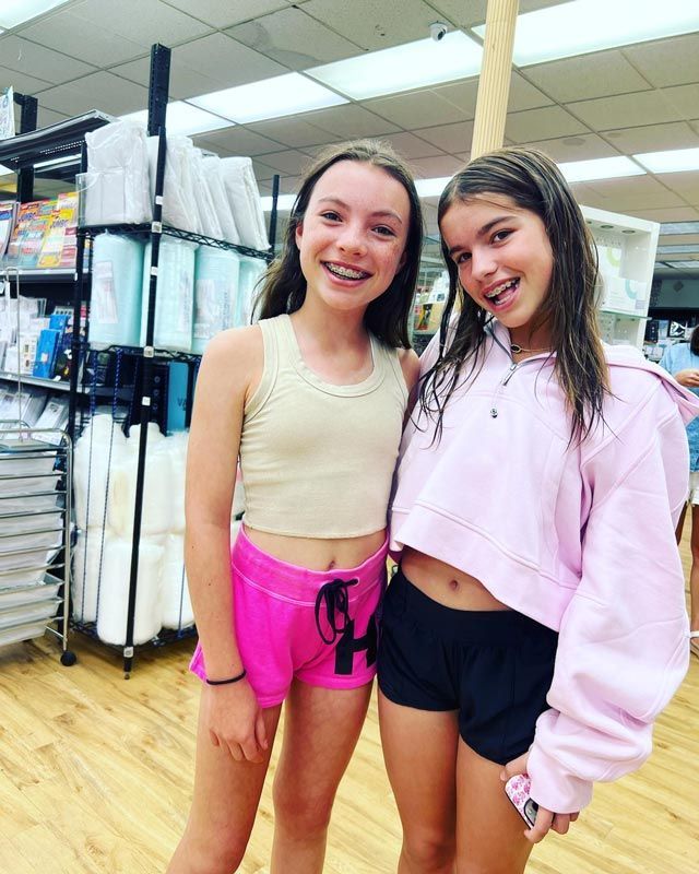 two young girls are posing for a picture in a store .