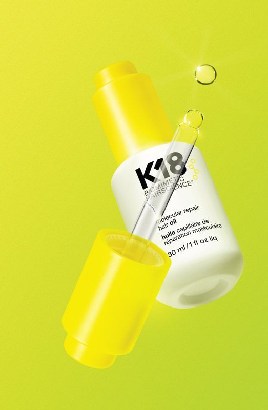a bottle of k18 serum is floating in the air on a yellow background .
