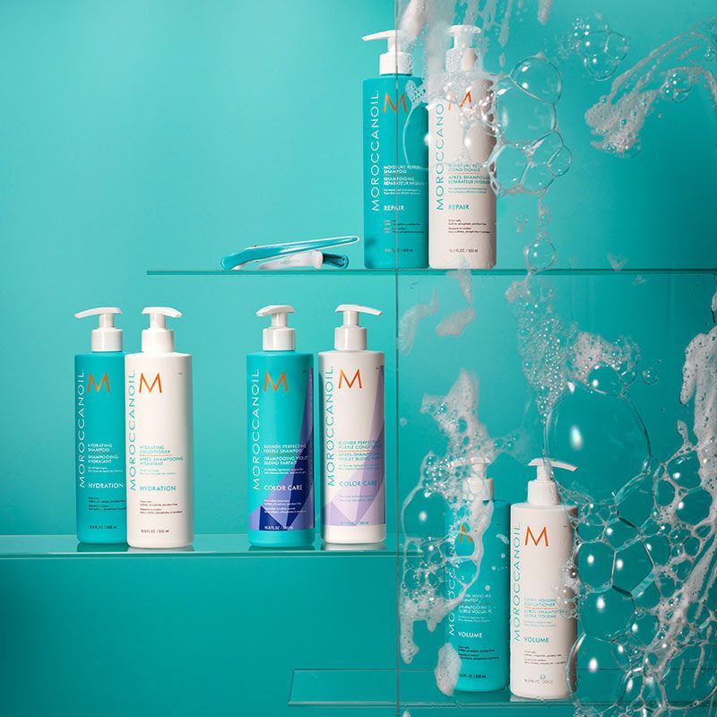 a shelf filled with bottles of shampoo and conditioner .
