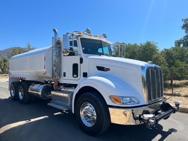 A white semi truck is parked on the side of the road.