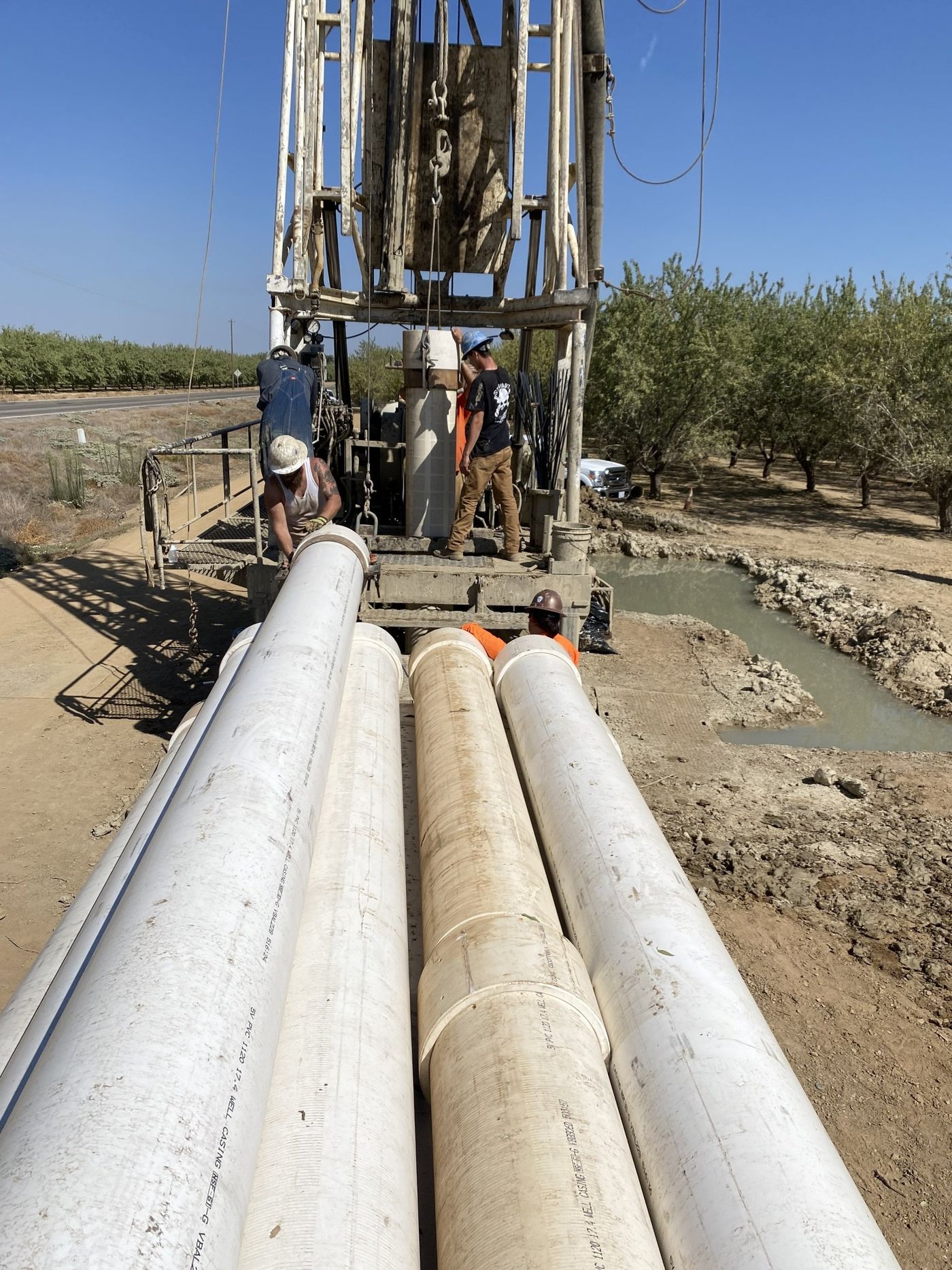 A group of men are working on a machine in a field