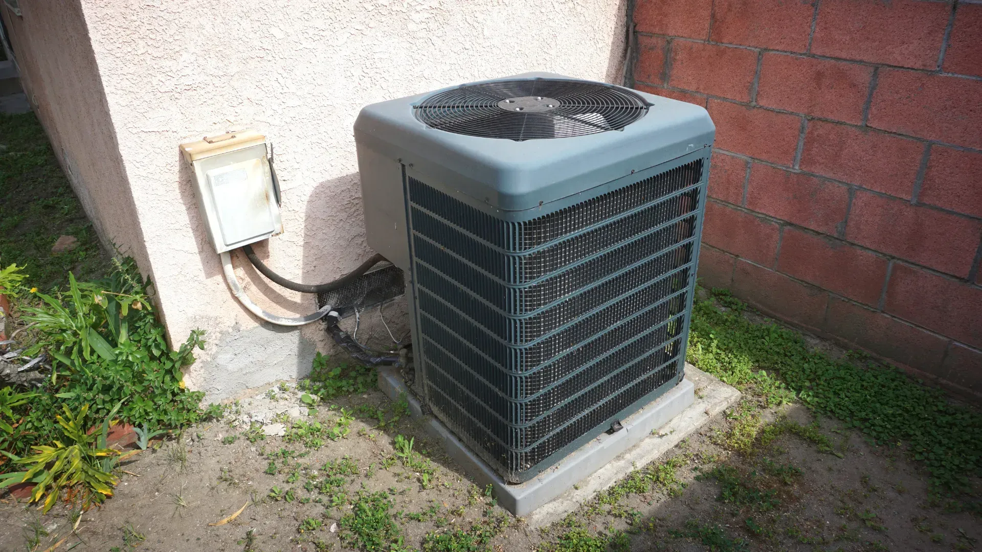 A large air conditioner is sitting on the side of a building.