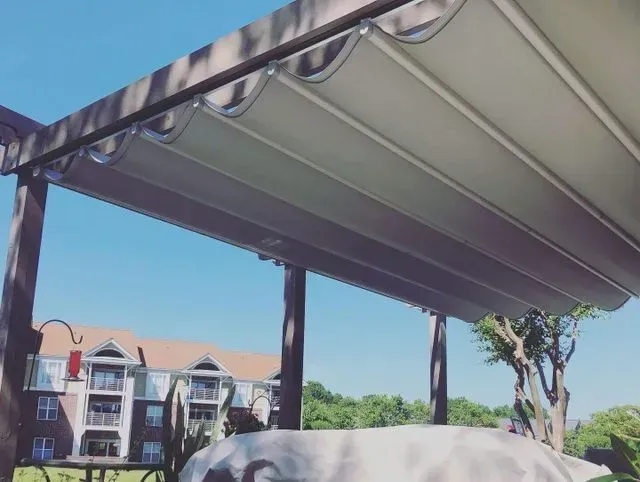 Apartment balconies seen beneath a gray awning against a bright blue sky