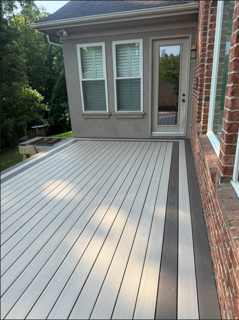 Brown composite decking material planks form terrace surface. Close-up view shows high-quality deck structure.
