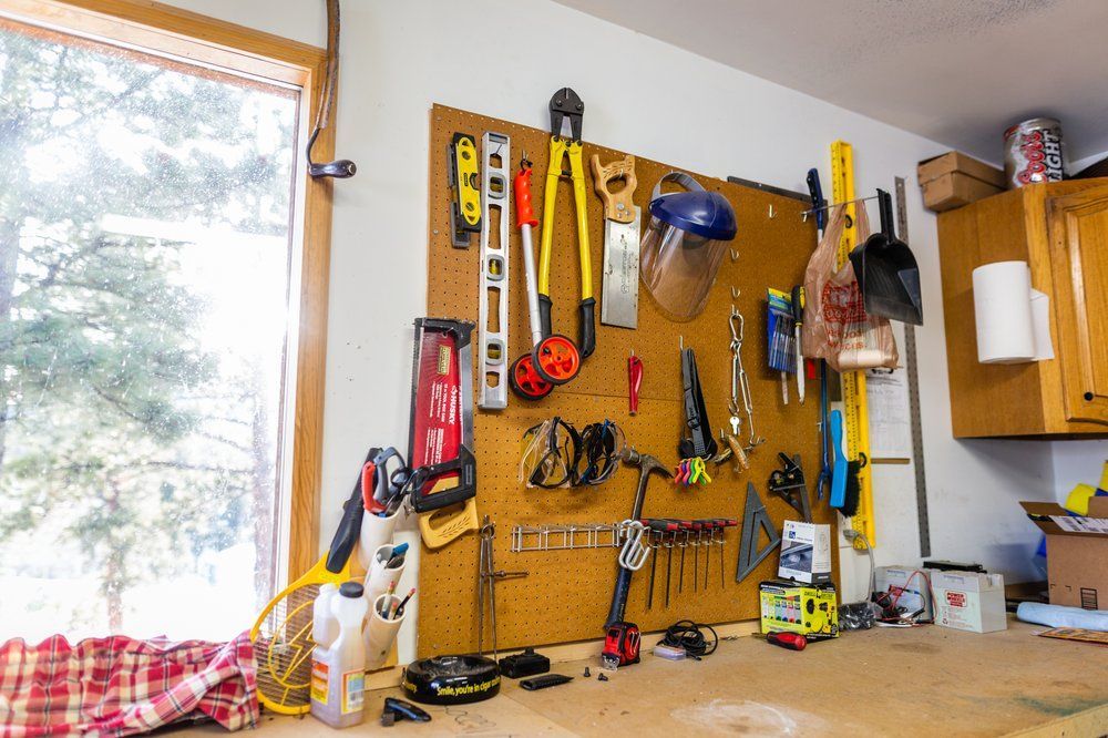 A workbench with a lot of tools hanging on the wall.