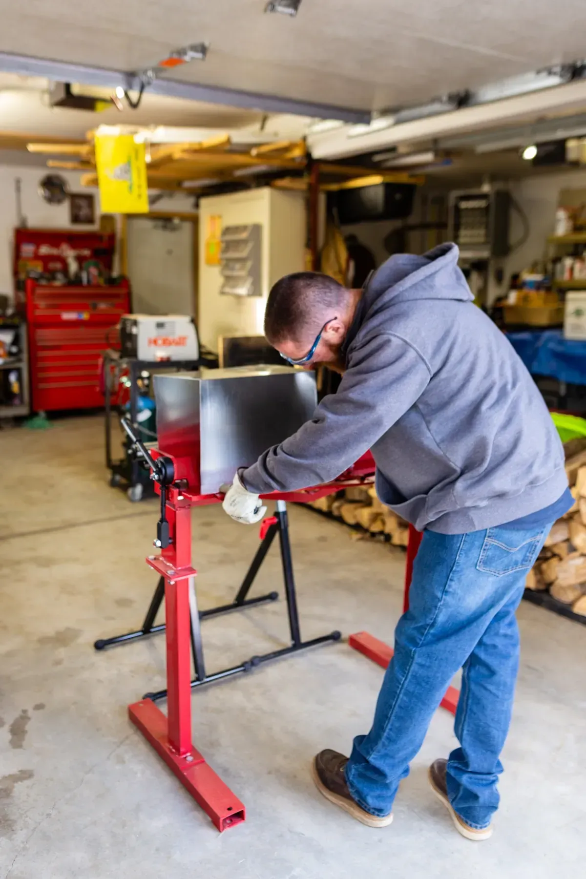 A man is working on a piece of metal in a garage.