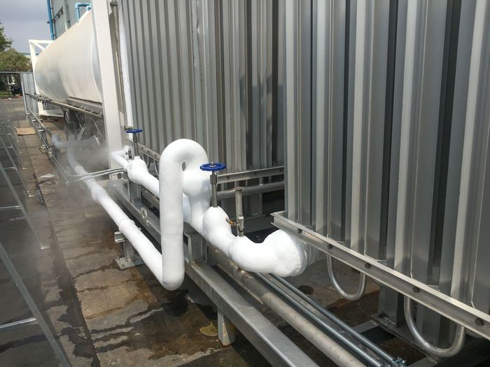 A bunch of pipes are connected to a building.