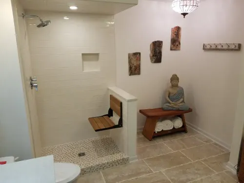 tile shower with a chair on a half wall