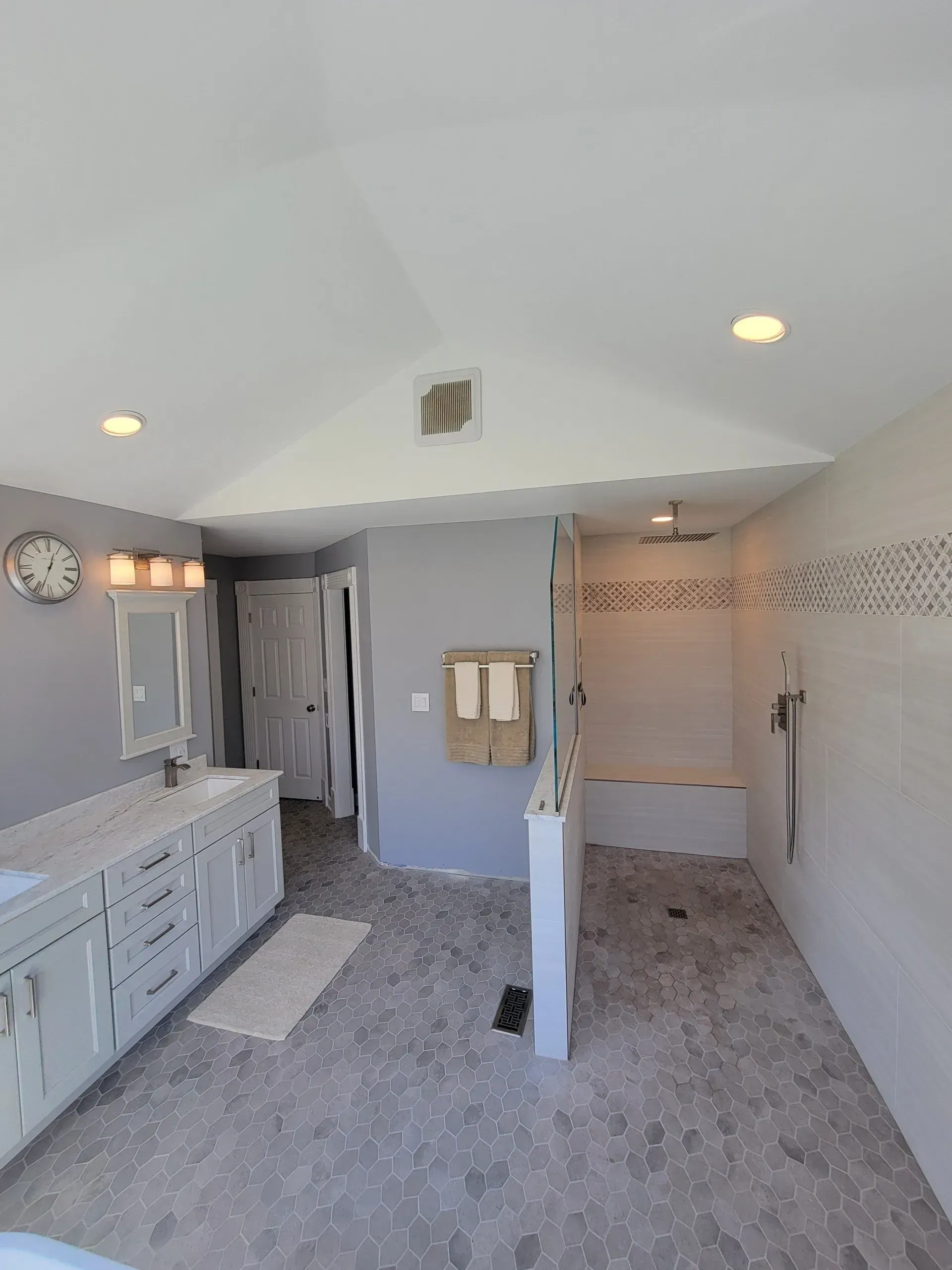 A bathroom with a walk in shower , sink , and mirror.